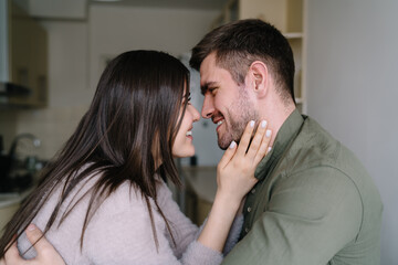 Happy couple looking into eyes in kitchen