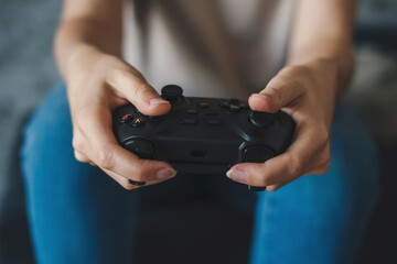 Close-up view of a woman's hands holding a joystick and playing video games. For lifestyle design. Computer entertainment. Computer gaming.