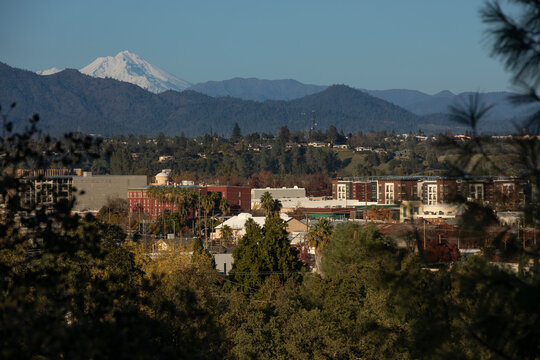 Afternoon snow covered view of the peak of Mount Shasta and the downtown skyline of Redding, California, USA.
