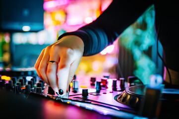 DJ Hands creating and regulating music on dj console mixer in concert nightclub stage