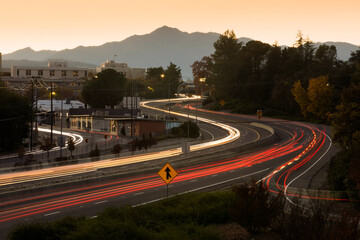 Sunset traffic passes on CA-44 through downtown Redding, California, USA. - obrazy, fototapety, plakaty