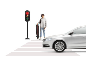 Guy with a longboard waiting waiting the green light on a traffic light at a pedestrian crossing