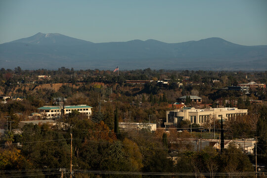 Redding, California, USA - November 22, 2021: Late afternoon sun shines on downtown Redding skyline with a mountain backdrop.