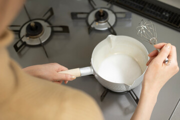 ガスコンロで料理をする女性	