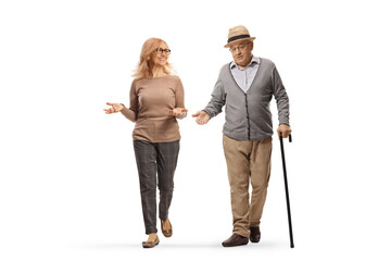 Elderly man with a cane and woman walking towards camera and talking