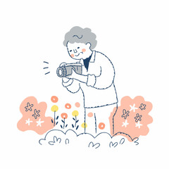 庭の花を撮影するシニア女性