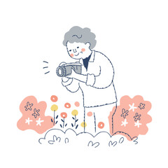 庭の花を撮影するシニア女性