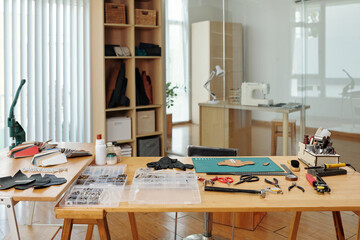 Table in workshop with everything for leather crafting on