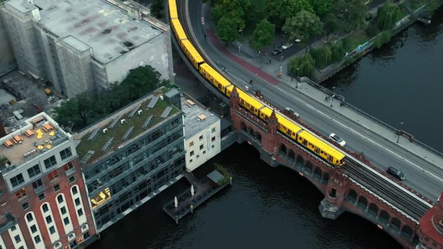 Aerial approach toward Oberbaum bridge with rapid transit train crossing, Berlin