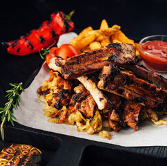 Close up gourmet main dish with grilled pork rib and fried potatoes