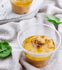 homemade hummus in a plastic cups with basil