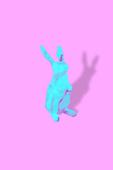 Obraz premium Blue-violet Easter ceramic bunny. Simple Easter photo. Pink background. 