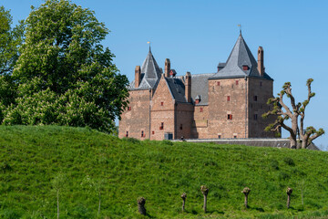 Fototapeta na wymiar Captivating view over the dike to Slot Loevestein Castle and its rich history. The fortress is the most famous in the Netherlands.