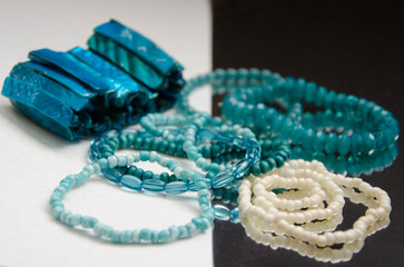 Fototapeta premium Blue and white beaded bracelets on the white and mirror surface