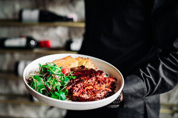 chef in black uniform hold in his hands ready beef steak ribeye meat