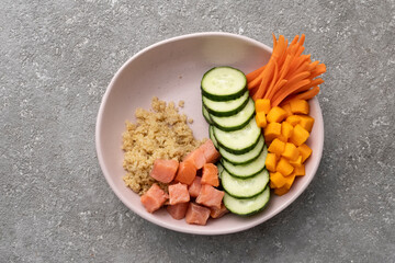 Boiled Quinoa with salmon and vegetables in a bowl on the table, a healthy lunch, a balanced diet