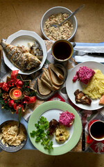 Christmas treats on the table, mashed potatoes, fried fish, appetizers and salads, top view