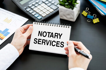 NOTARY SERVICES text on paper notepad with pen in hands of business woman. Business concept
