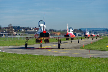 Red and white Northrop F-5E Tiger II fighter of Patrouille Suisse taxiing to hangar at Swiss Air...