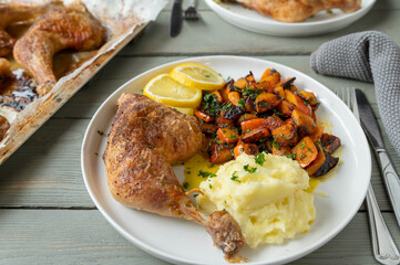 Oven baked chicken leg with marinated pumpkin salad and mashed potatoes on a plate