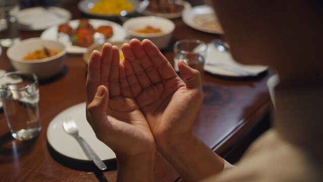 Close-up Islam Woman Hand Pray. Happy Asian Muslim Family Praying To God Before Eating Ramadan Dinner At Home. Two Generation Celebration Of Eid Al-Fitr Togetherness At Home. Hari Raya Family Reunion.