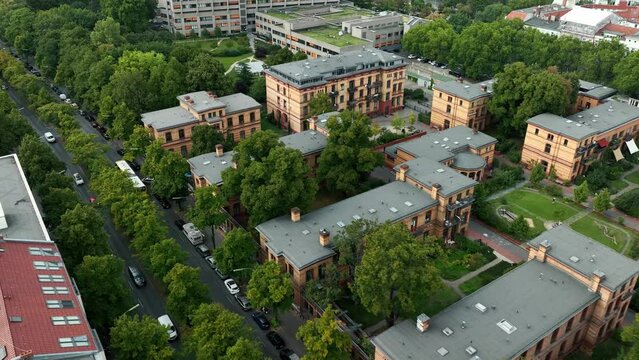Typical Berlin Neighbourhood residential area in sunny daylight with view on  rooftops and main Street, Aerial Wide Establishing Shot