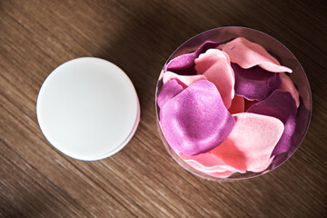 Scented bath petals and a jar of cream. Spa procedures. Up close