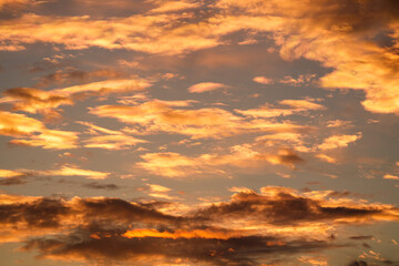 Naklejka na ściany i meble Orange sunset sky. Beautiful sky landscape with spectacular clouds. Wallpaper photo.