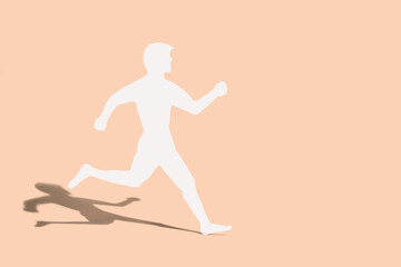 Fototapeta na wymiar Male silhouette is running on a beige background. Concept, speed, running, healthy lifestyle