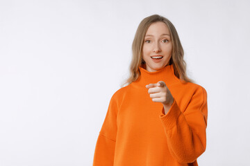 Fototapeta na wymiar Hey you. Portrait of beautiful cheerful young woman pointing finger at camera and smiling, congratulating you, praising or inviting. You got this