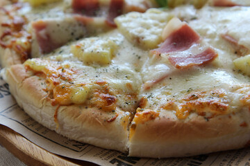 Homemade hawaiian pizza ready to eat on wooden plate