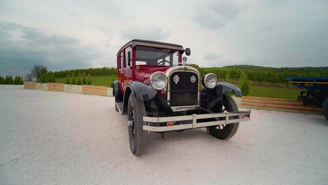 Red retro car with polished carcase on private land. Auction. Close up old fashioned polished shiny red vehicle.