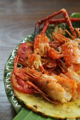 Shrimp shell and head waste after eating full on banana leaf on ceramic plate