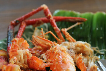 Shrimp shell and head waste after eating full on banana leaf on ceramic plate