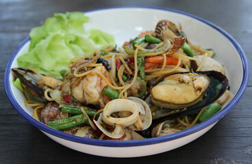 Stir fried spaghetti seafood on white ceramic plate