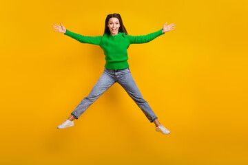 Fototapeta na wymiar Full body portrait of satisfied pretty lady jumping raise hands good mood isolated on yellow color background