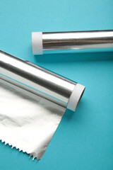 Rolls of aluminum foil on blue background. Vertical photo