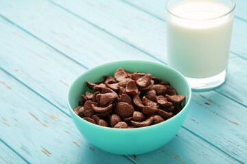 Set of various breakfast cereals with glass of milk on blue background.