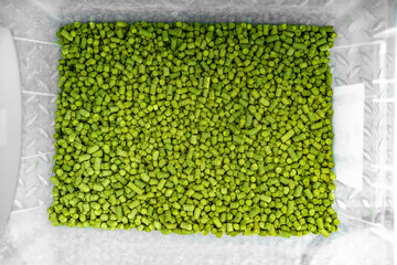 hops in green colored granules for the production of beer in a brewery