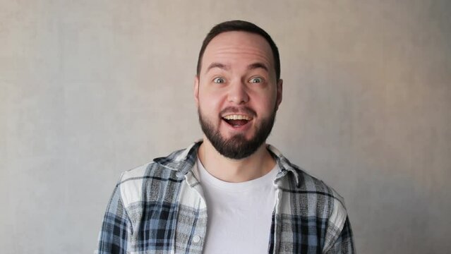 Adult handsome caucasian man with beard getting excited and surprised looking at camera