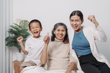 My grandmother and daughter and grandson hugged lovingly while sitting on the sofa with care and warmth, love, valentine, family, care.