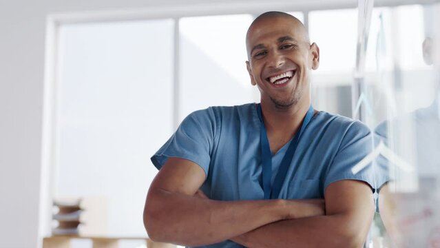 Happy, confidence and face of a doctor in his office after a consultation in the hospital. Happiness, smile and portrait of a male healthcare worker standing with crossed arms in a medical clinic.