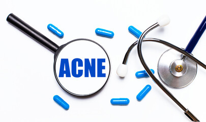 A doctor's workplace with various office supplies, such as a stethoscope, a magnifying glass with the text ACNE and pills, top view.