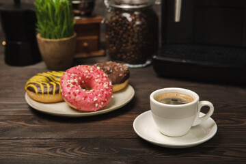 Fragrant delicious espresso coffee with pink strawberry donut, coffee machine on brown texture table. Good morning concept. Morning coffee. Sweet table. Colorful berry buns.Top view.