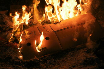 Cardboard banana box on fire that looks like it's screaming with flames  and smoke billowing...