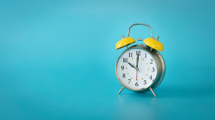 Retro silver alarm clock. 10:00, am, pm. Blue background.