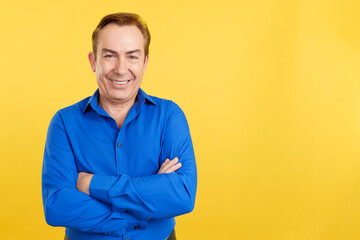 Mature man smiling at the camera standing with arms crossed