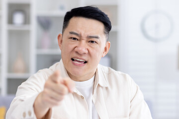 Video call online meeting, mature adult asian looking at camera angry man shouting angry,...