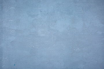 Blue background of decorative plaster with abstract spots. Unusual texture of this wall with beautiful patterns, creative surface background. Finishing coating for building cladding.