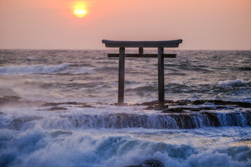 a floating tori gate at sunset, japanese, ocean waves breaking at sunset over a wooden tori gate, 